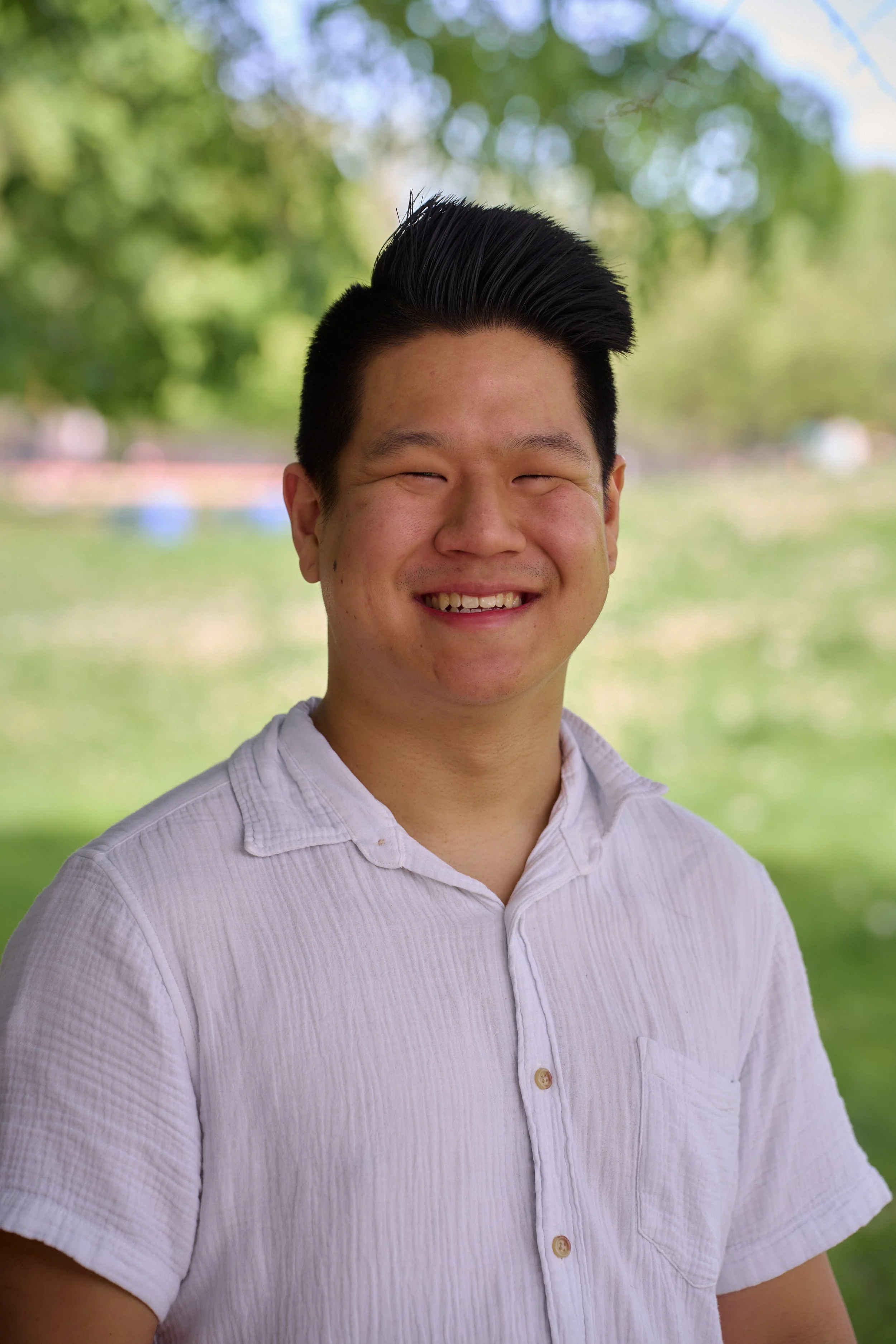 Person holding a small brown and black dog outdoors.