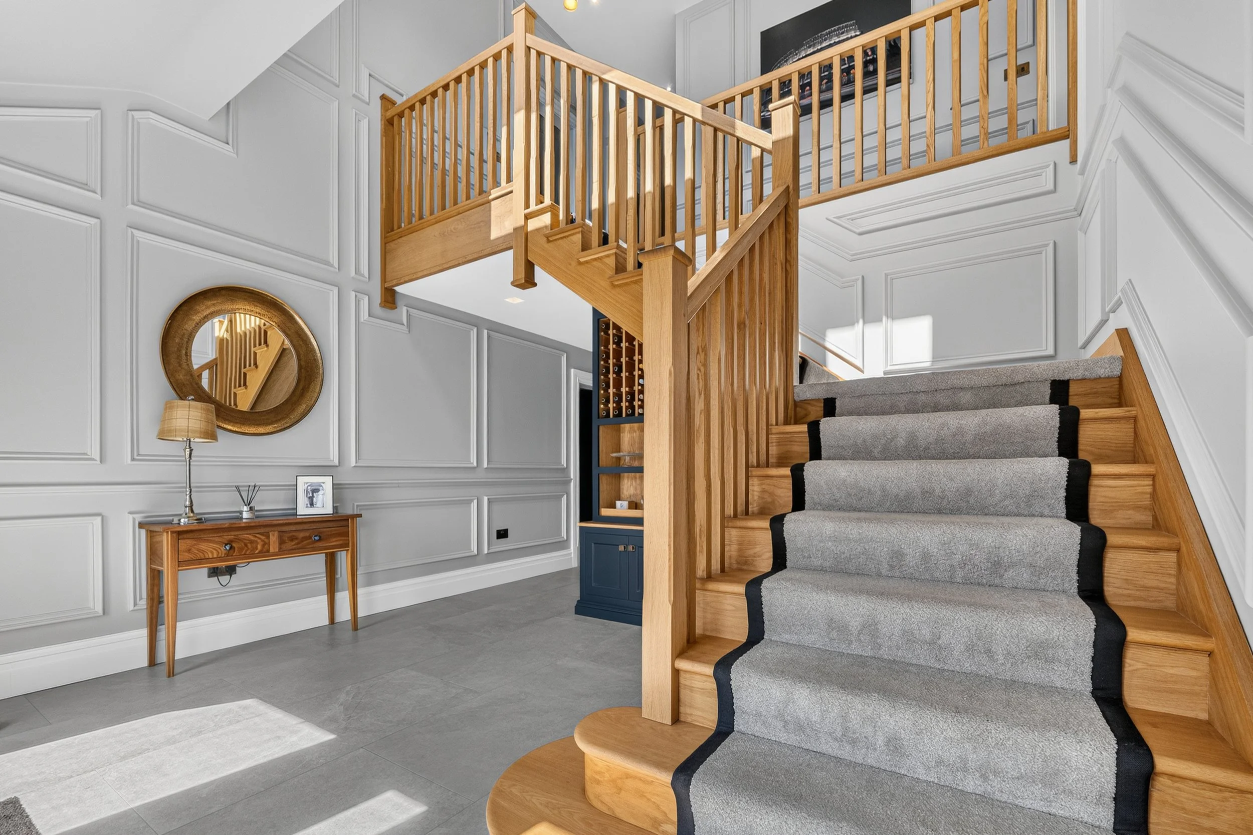 Professional interior property photography showing a bright entrance hall and oak staircase.