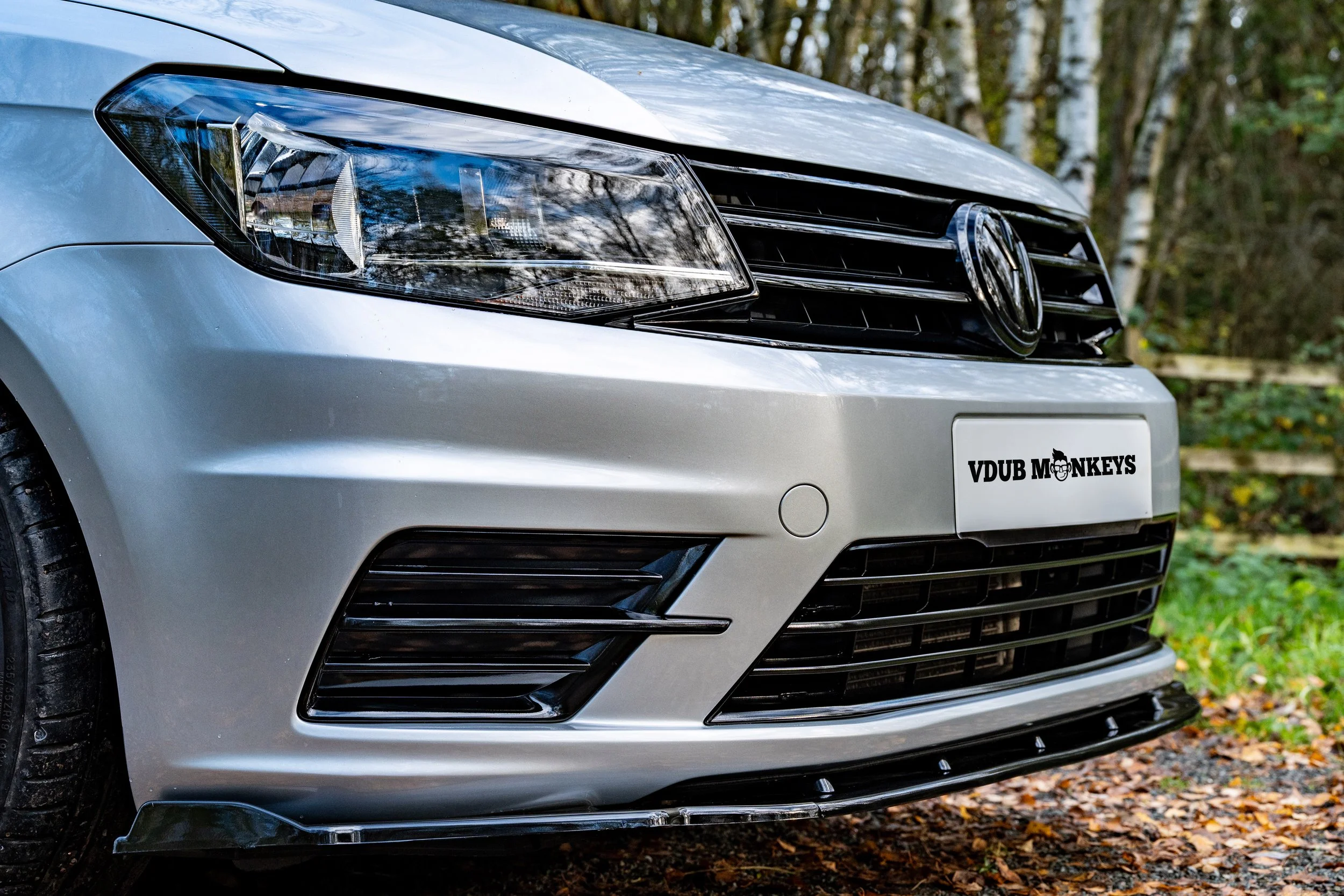 Commercial automotive photography showing a close-up of a vehicle headlight and front bodywork.
