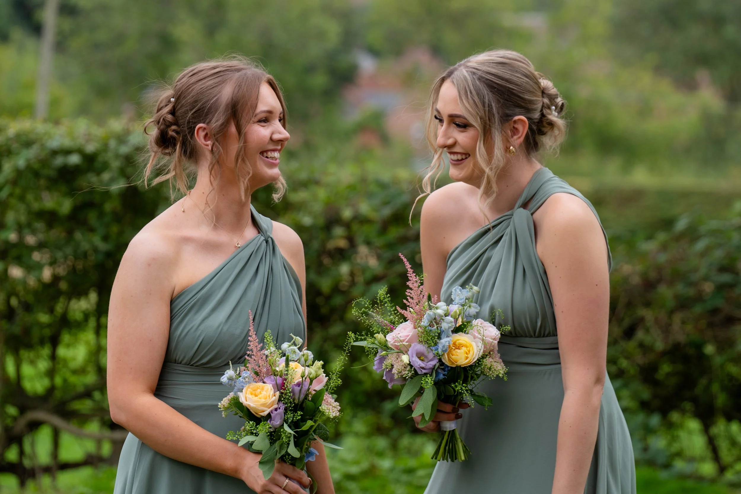 Candid wedding photography of two guests smiling and talking during the celebration.