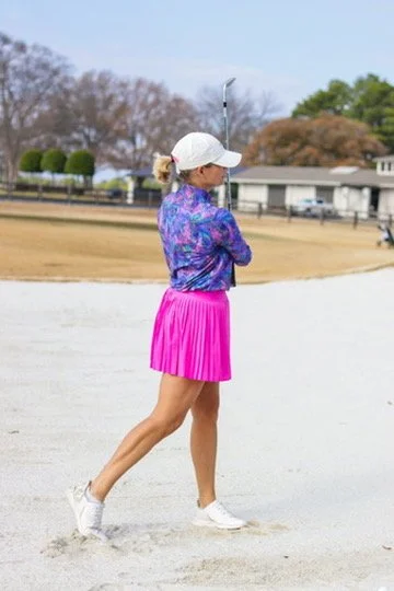 pink golf skirt, hitting out of the bunker, what to wear golfing for women