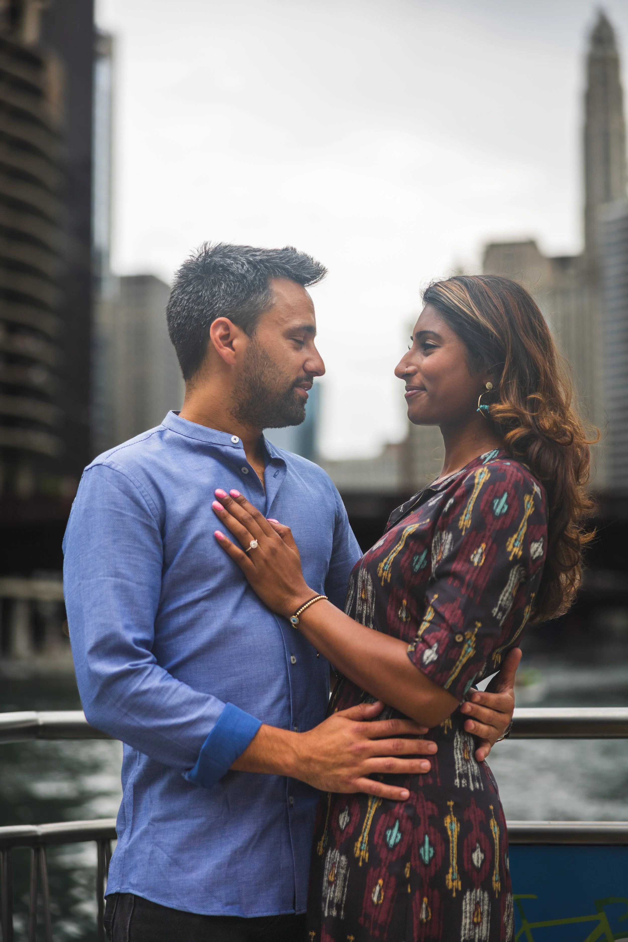 Couple embracing in front of the skyline on the Chicago Riverwalk