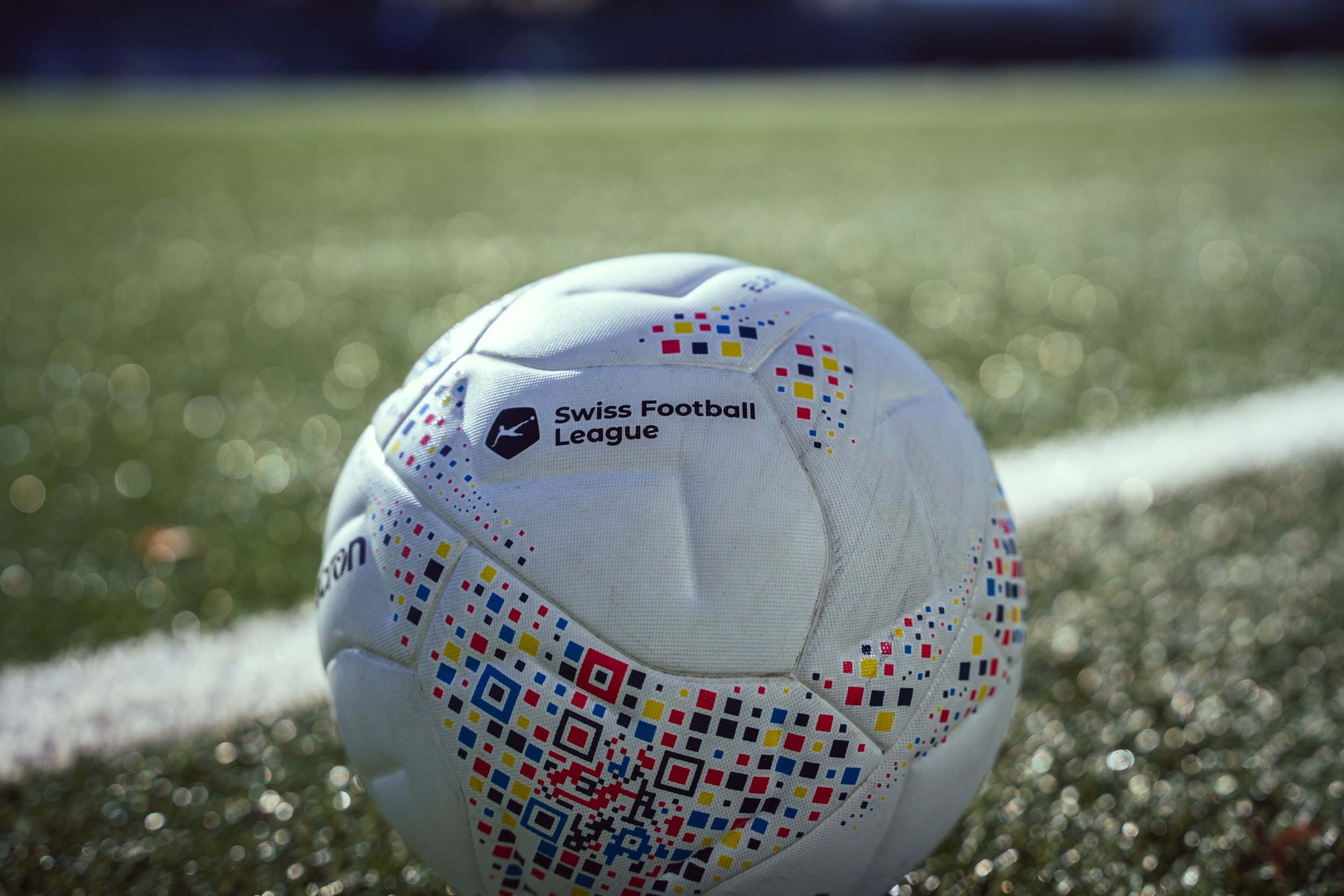 Nahaufnahme eines Fußballes der Swiss Football League auf einem Fußballfeld.
