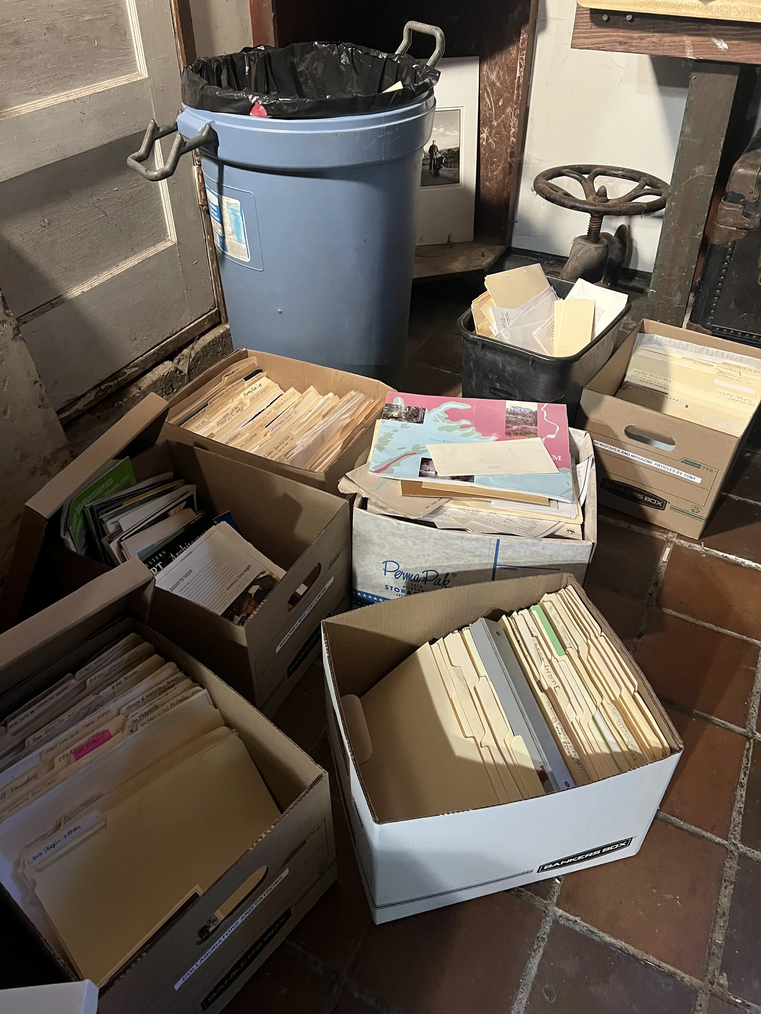 Bankers boxes filled with papers to sort sitting in corner of studio