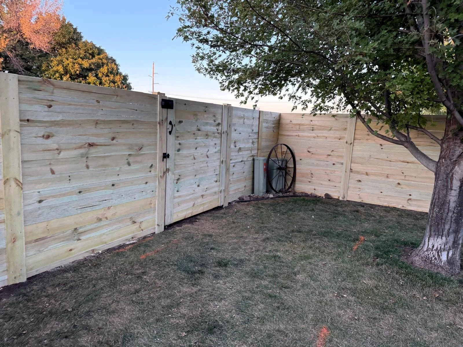 Professional fence corner installation with horizontal wood planks.