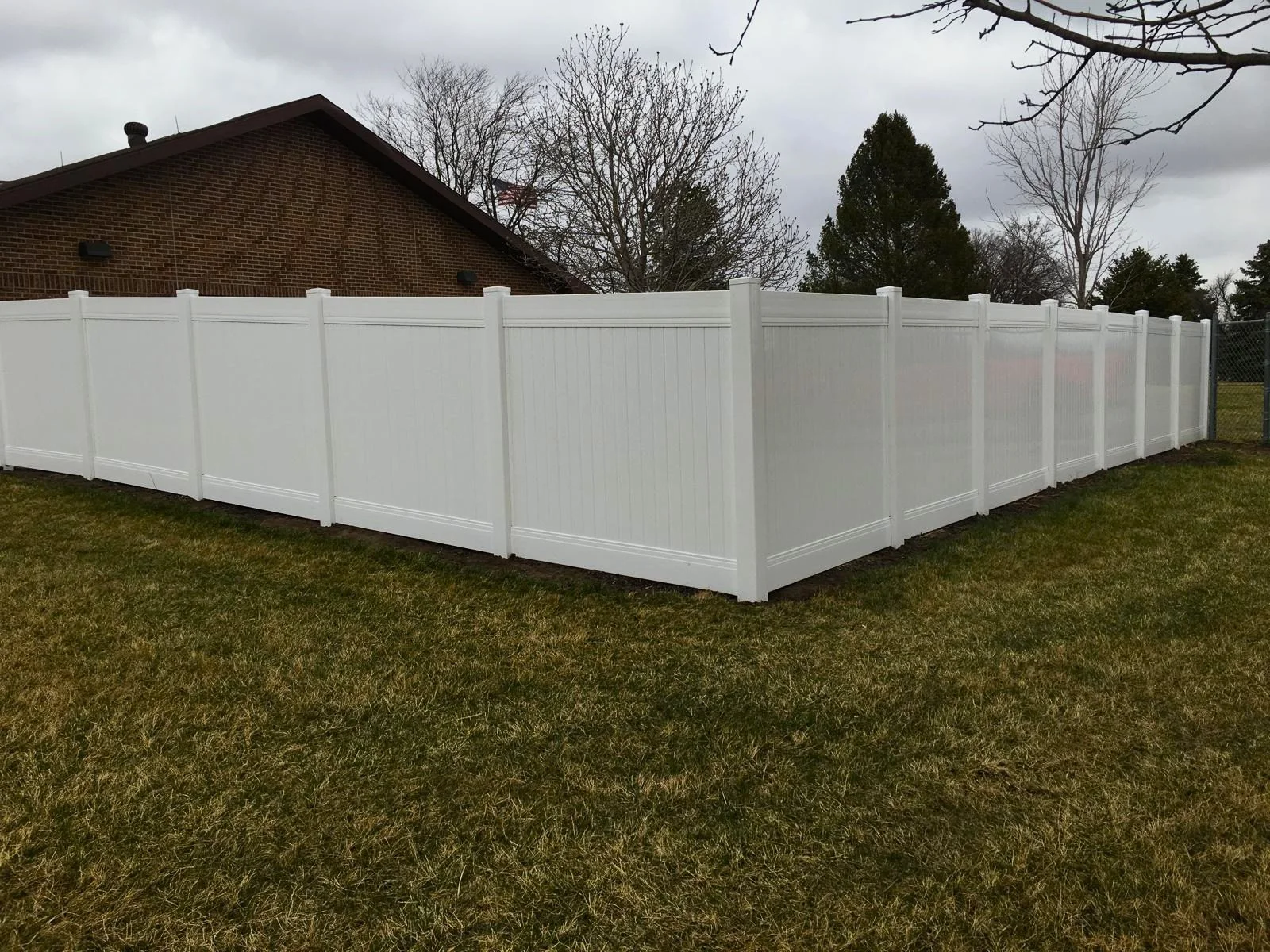 Complete vinyl fence enclosure for a residential property, built to withstand South Dakota wind and weather