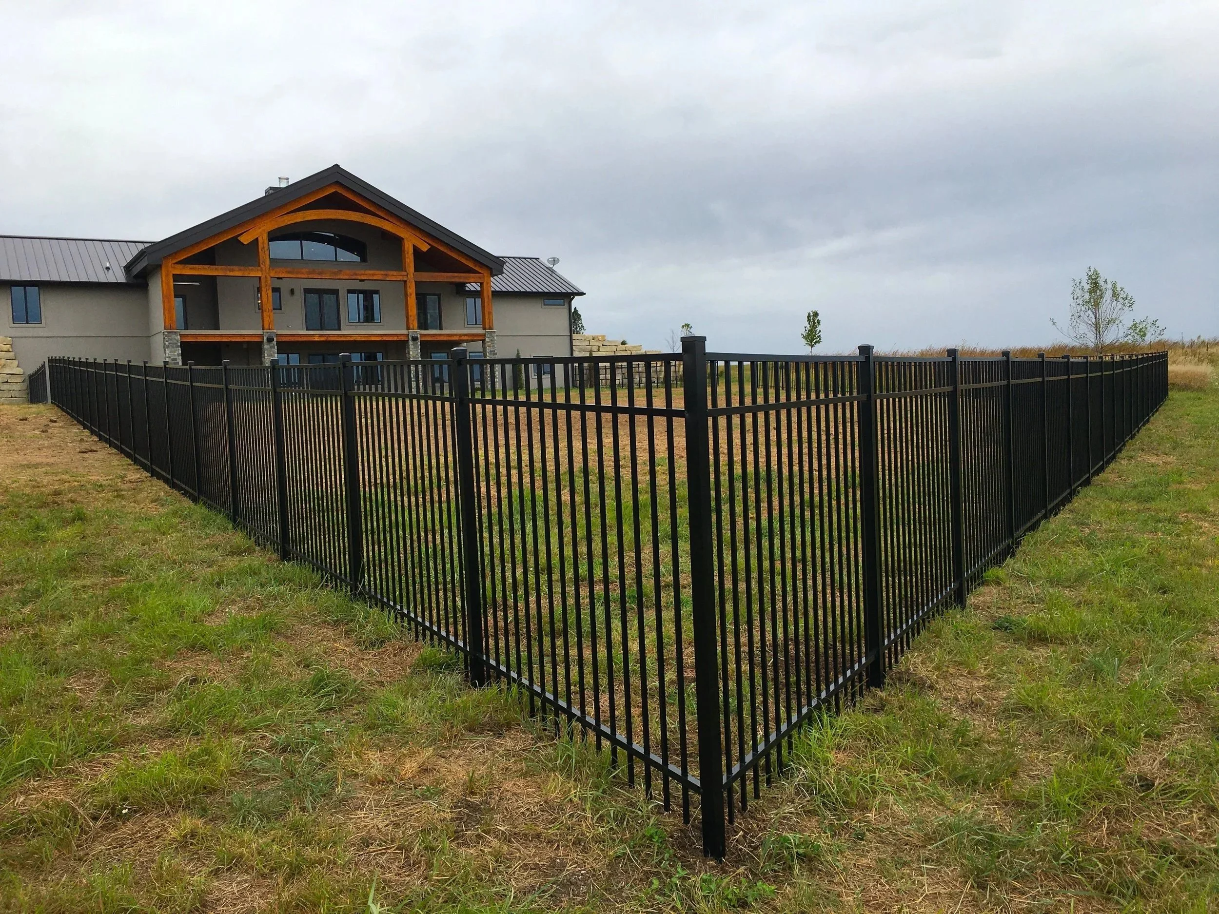 Black aluminum fence installation for home security in Sioux Falls