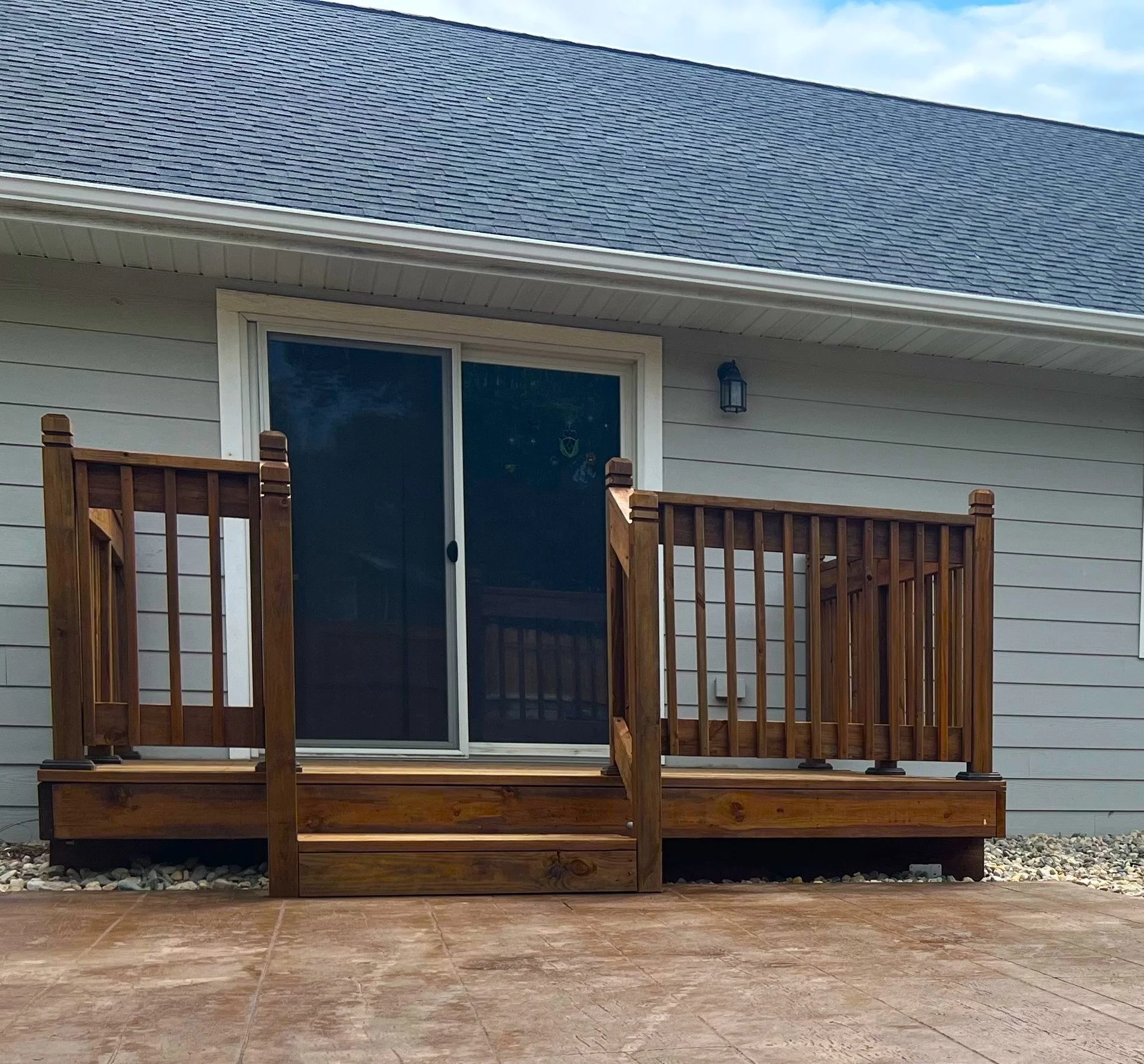 Small residential wood deck installation with sliding door access in Sioux Falls