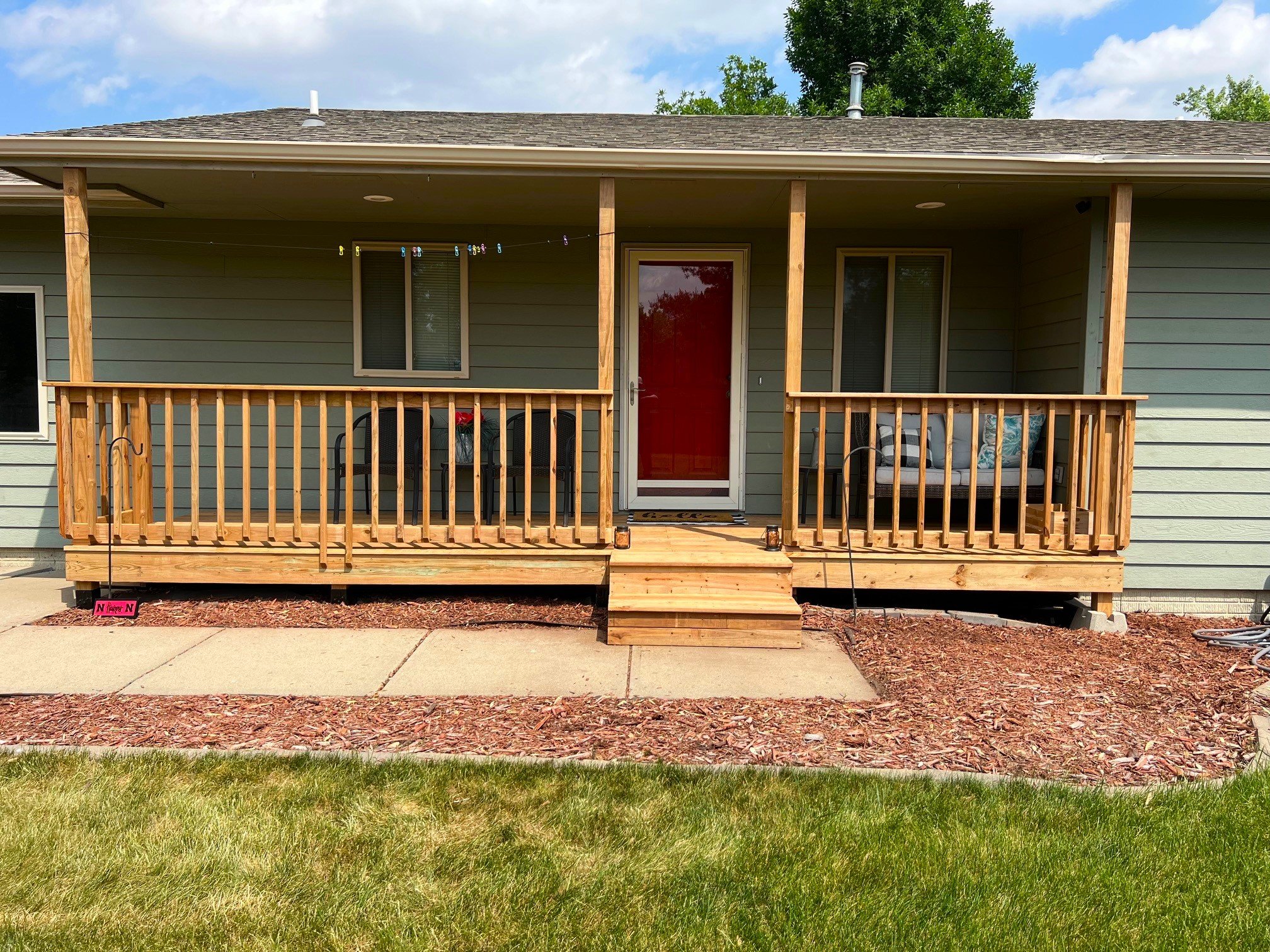 Wood deck entrance with railing and red front door in Sioux Falls SD
