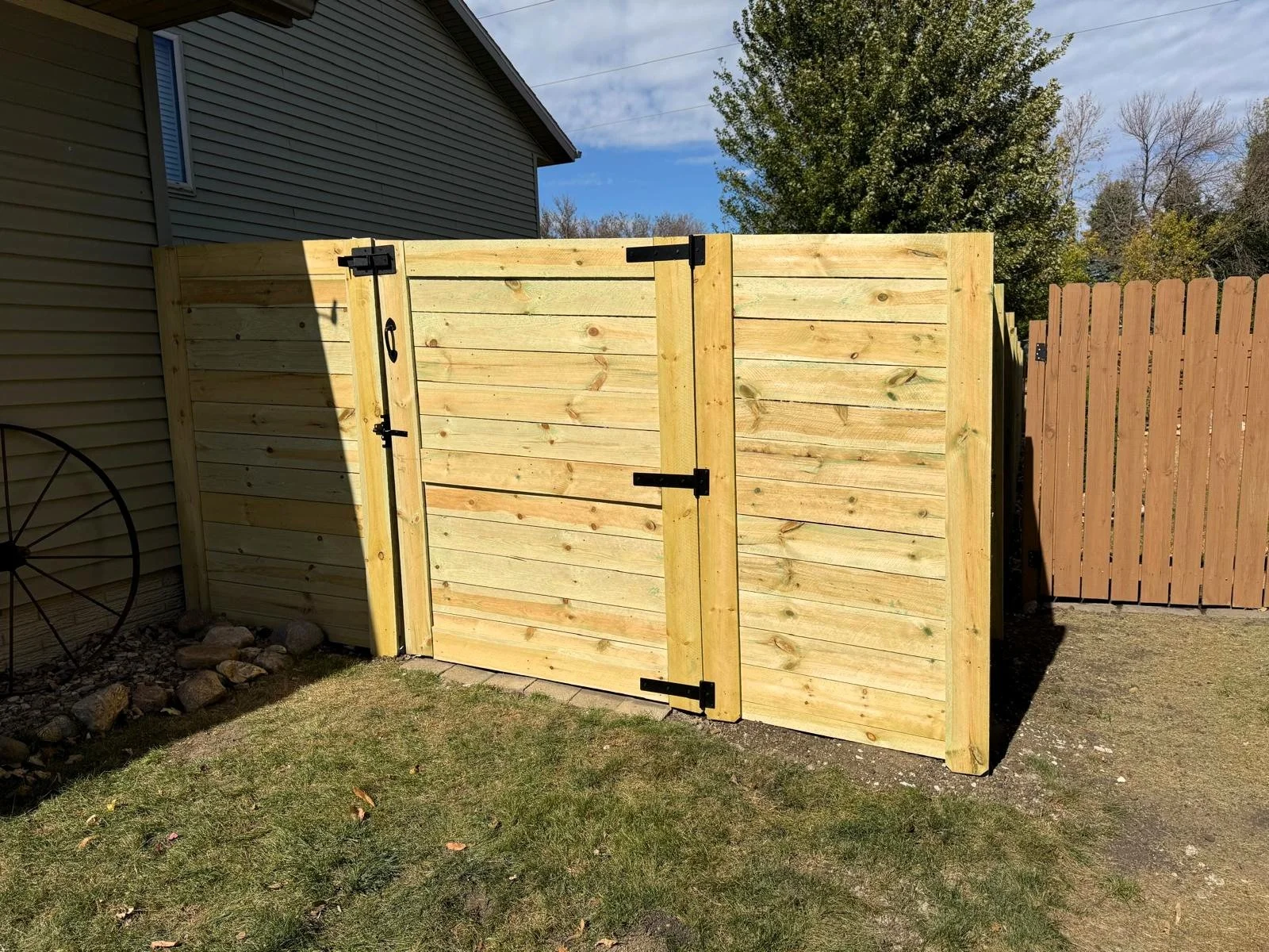 Custom horizontal wood gate and fence installation in Sioux Falls.