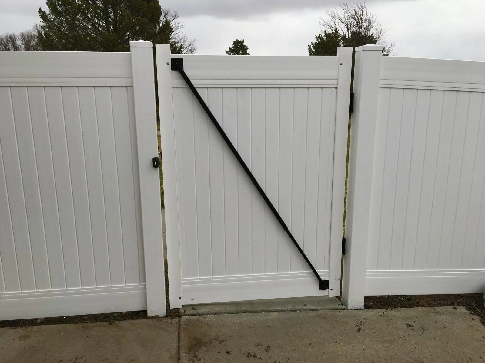 Detail of a reinforced vinyl fence gate with heavy-duty hardware for long-lasting security