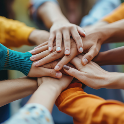 Group of diverse hands stacked together, symbolizing unity and teamwork. Prodigal Heroes Community