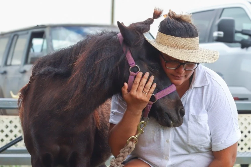 Guest hugging mini horse Chyna for a photo.