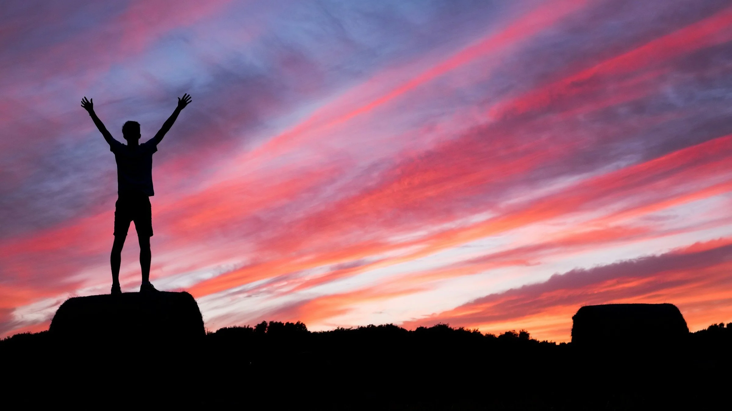 Silhouette of person with arms raised upwards.