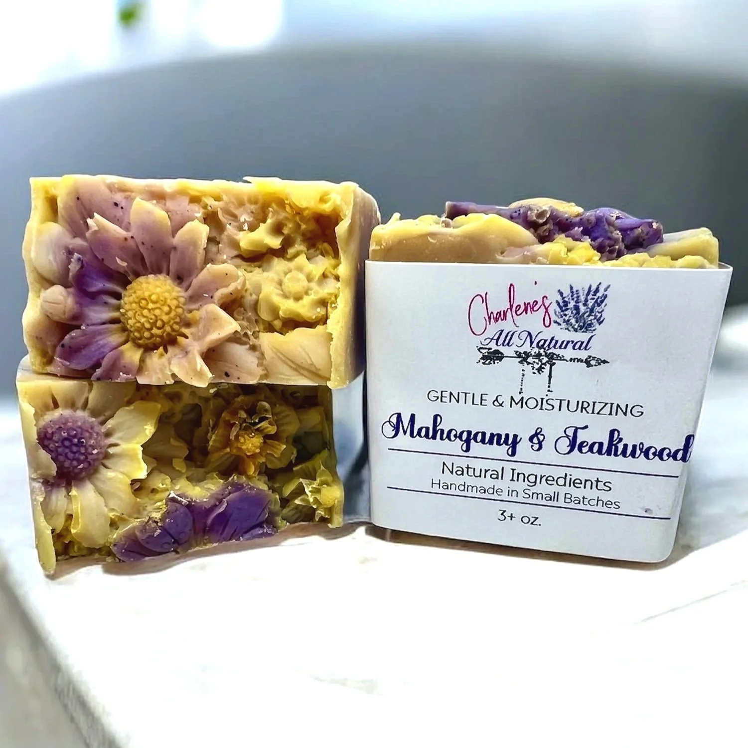 Artisan-made bar of soap. Mahogany and Teakwood soap offers a unique citrus, floral, and woody aroma. These bars have decorative flowers on top and nourishing benefits for your skin.