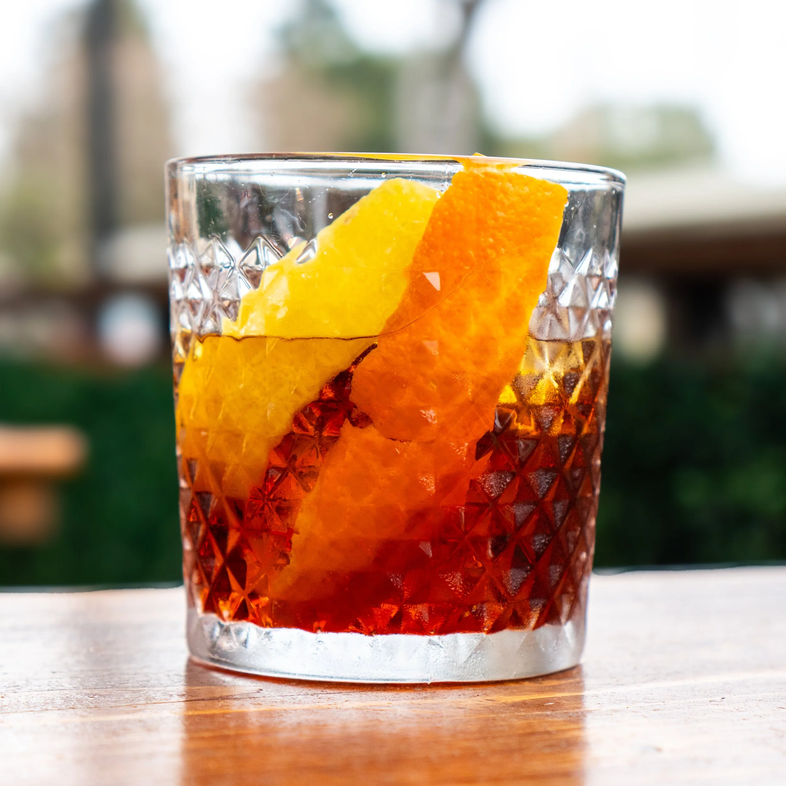 A glass of cold sangria with slices of orange and lemon on a wooden table at cocktail bar in DC.