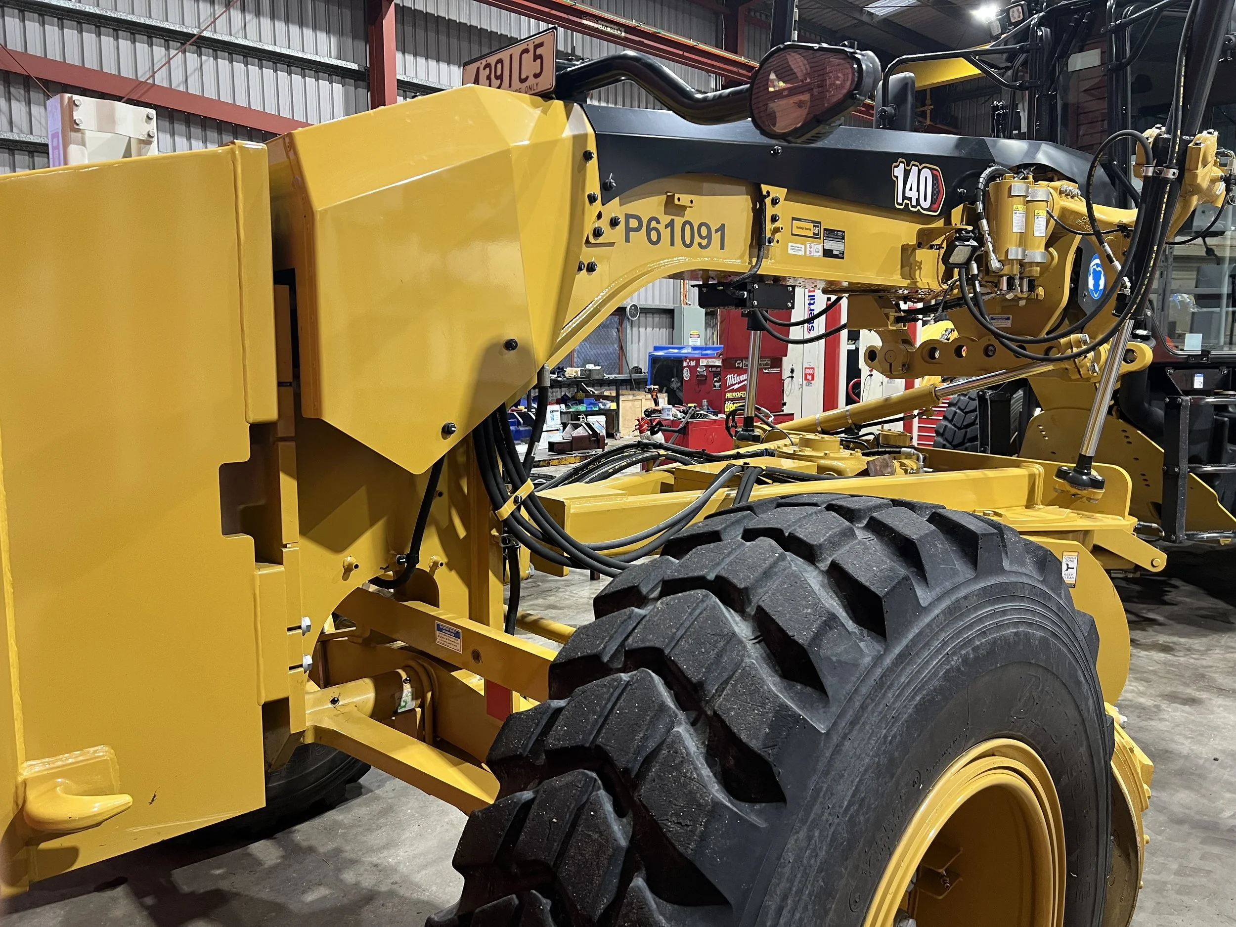 Guidemate G-Track 3D Grader Control System being installed on a road grader in a workshop