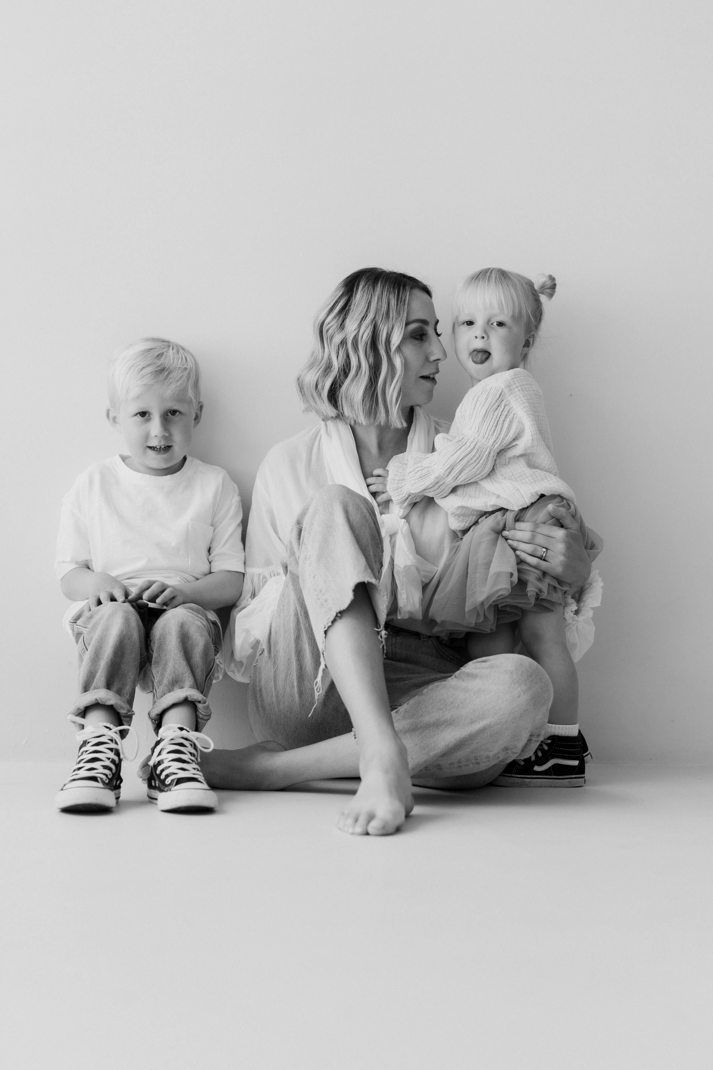 Mother, Son and Daughter, black and white studio portrait, little girl in tutu poking out her tongue 