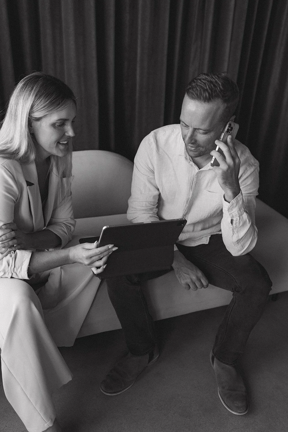 Corporate branding image of a man and woman with a laptop sitting down