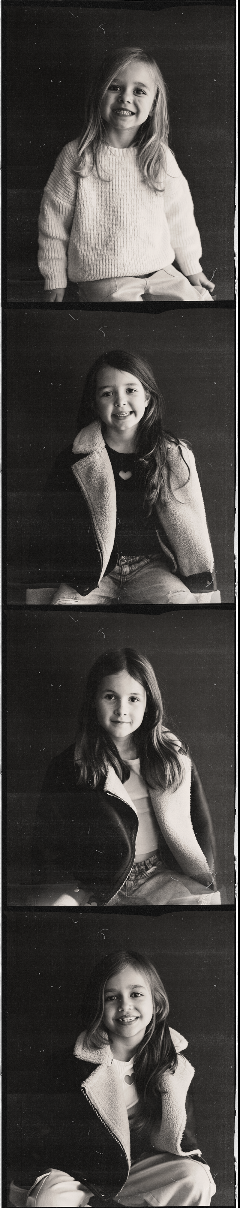 Four black-and-white portrait photography of young girls, each smiling and dressed in casual clothing, against a dark background.
