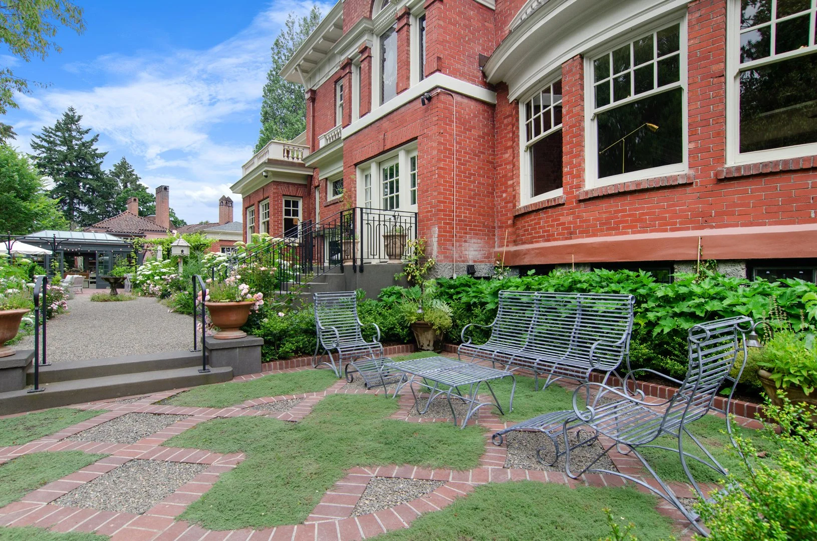 The knot garden, in addition to being a lovely place to sit, is meant to be viewed from the formal living room above, and features delicate-looking steel furniture that allows rain and sun to reach the groundcovers below.