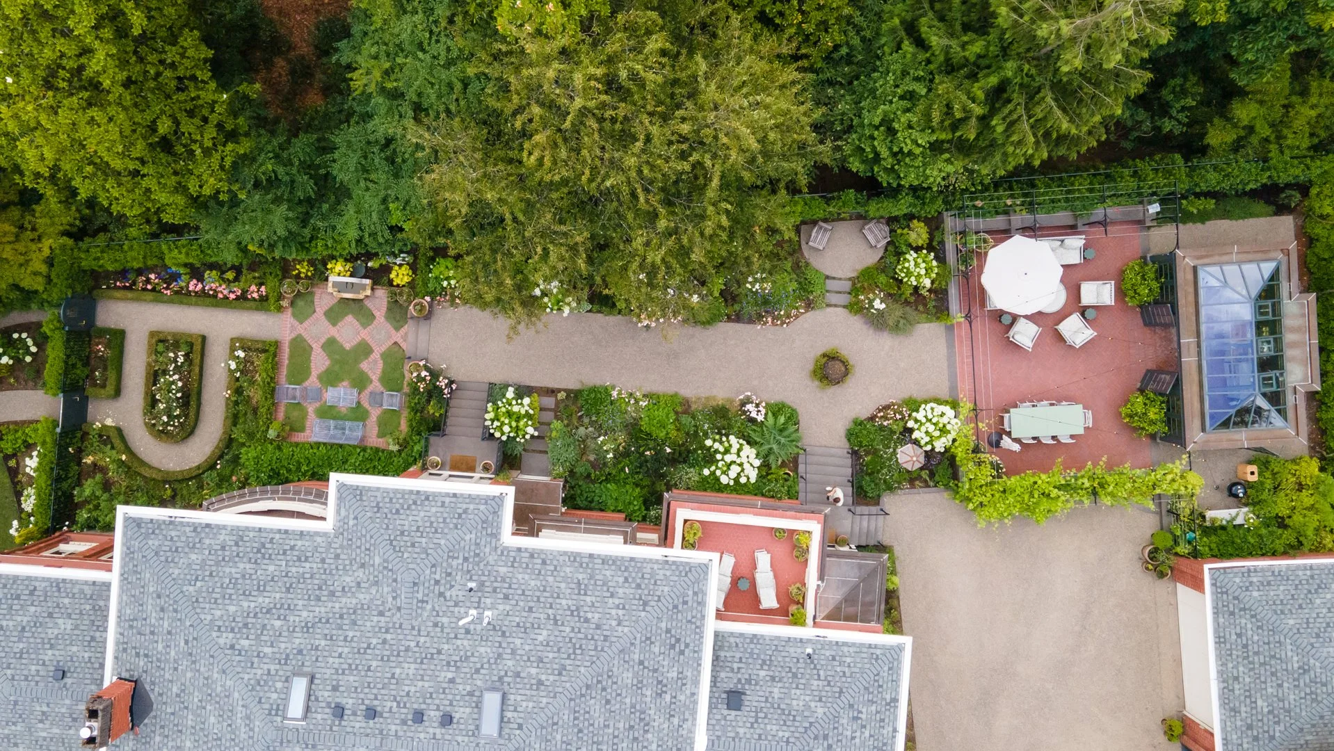 The back yard is divided into a series of outdoor rooms, from left to right: rose garden, knot garden, perennial walk, and greenhouse terrace.