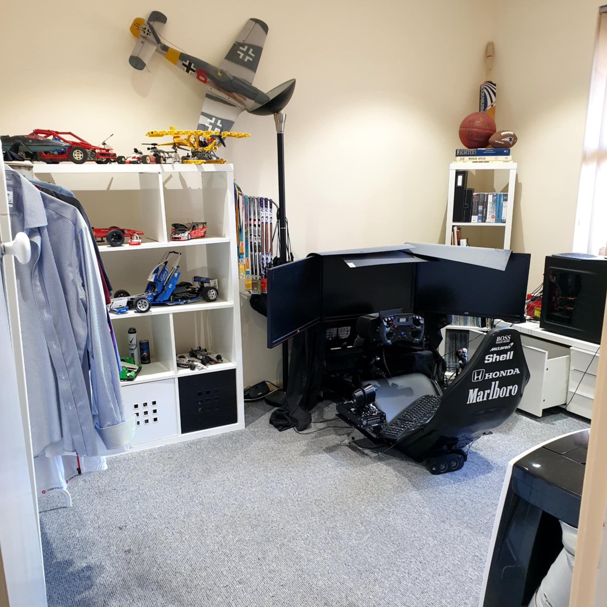room with racing simulator, model planes, and LEGO models