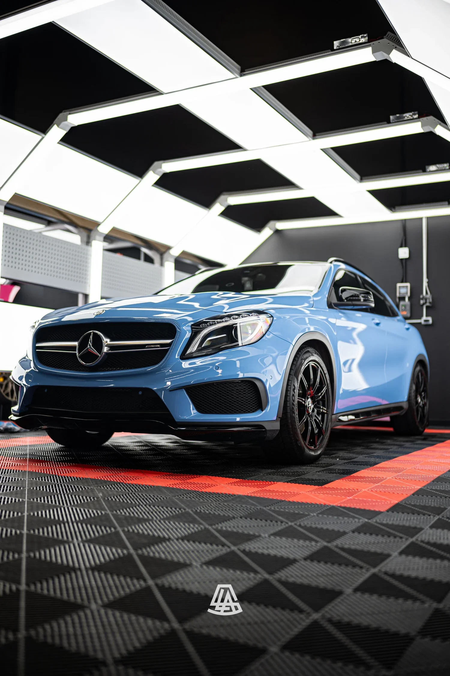 Mercedes hatchback in a light blue vinyl wrap inside the Luminous Auto Salon shop in Calgary