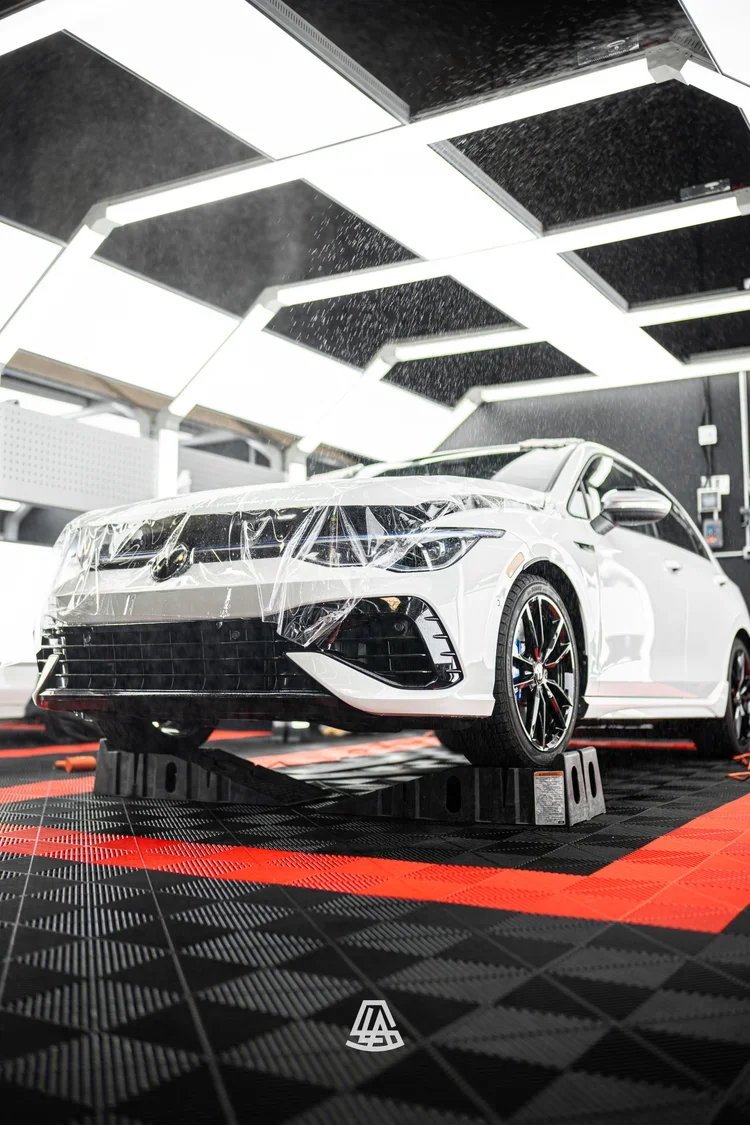 White car with partially installed paint protection film