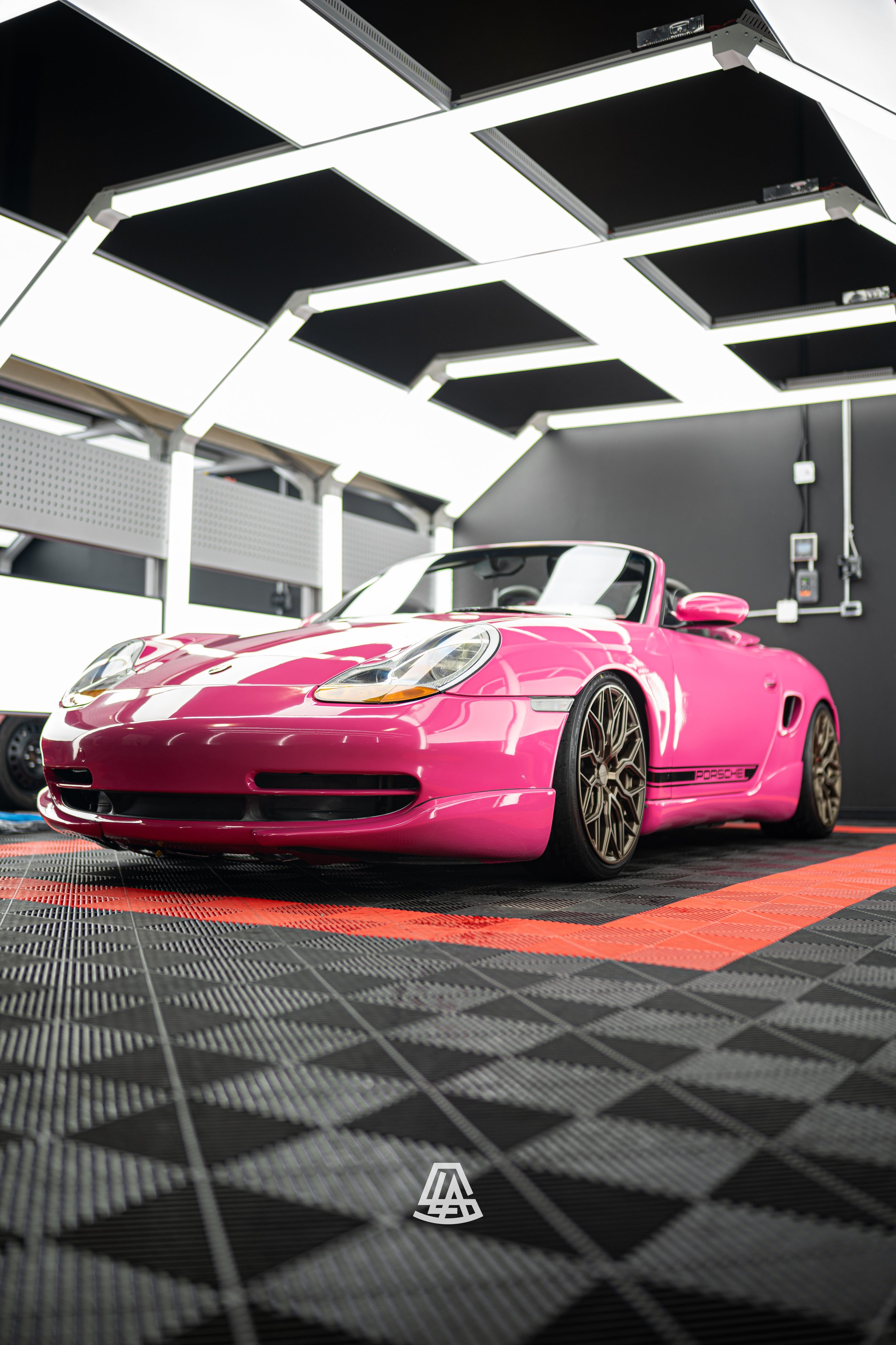 Gloss pink colour change wrap on a Porsche convertible inside the Luminous Auto Salon Calgary shop