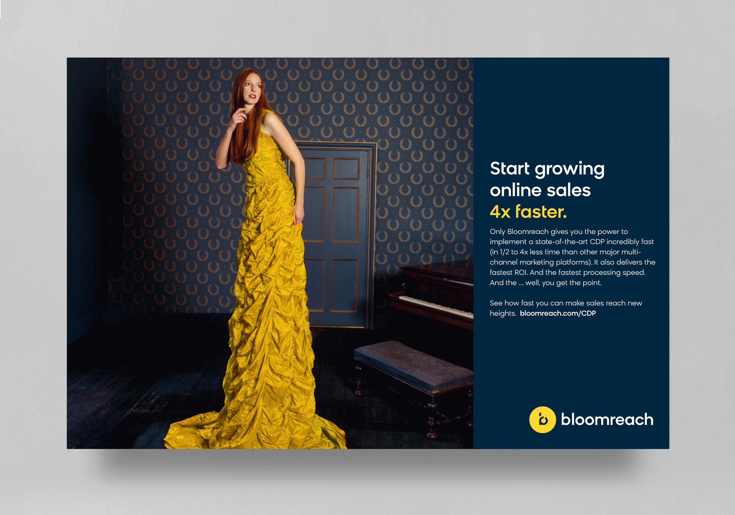 A woman with long red hair in a vibrant yellow ruched gown, standing in a room with dark patterned wallpaper and a blue door. She is looking to the side, touching her face, and standing near a piano.