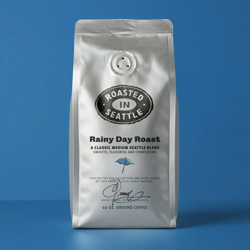 A silver bag of roasted ground coffee labeled "Rainy Day Roast" with the brand name "Roasted in Seattle" and a blue umbrella icon, set against a blue background.