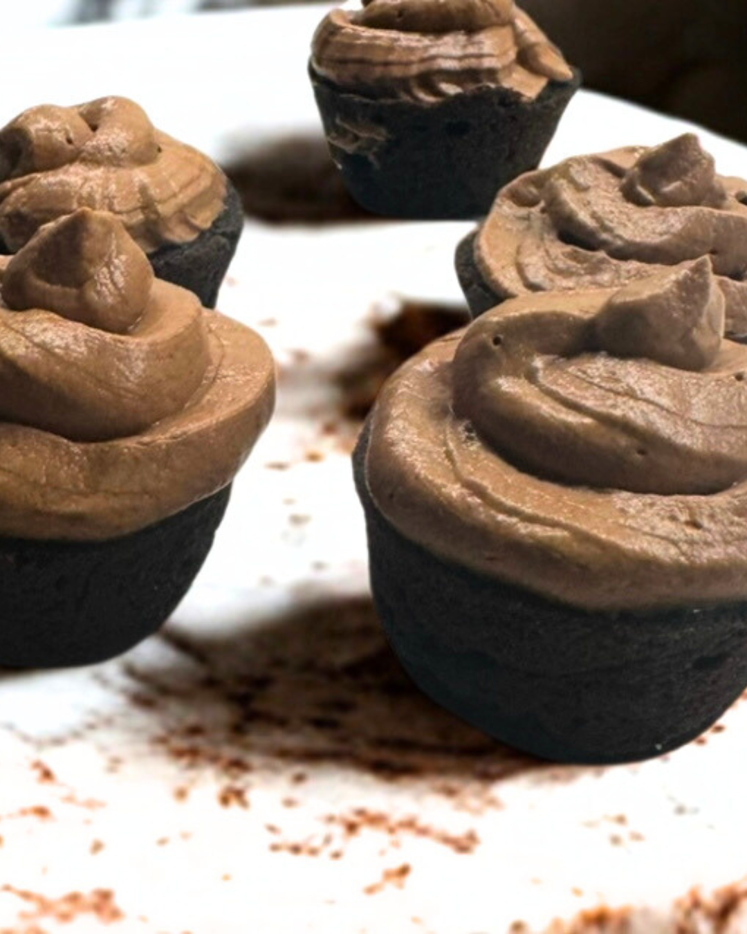 Mini carob dog cupcakes made in Ottawa with organic coconut oil, rice flour, and carob powder, topped with yogurt and peanut butter icing—wholesome, bite-sized dog treats.