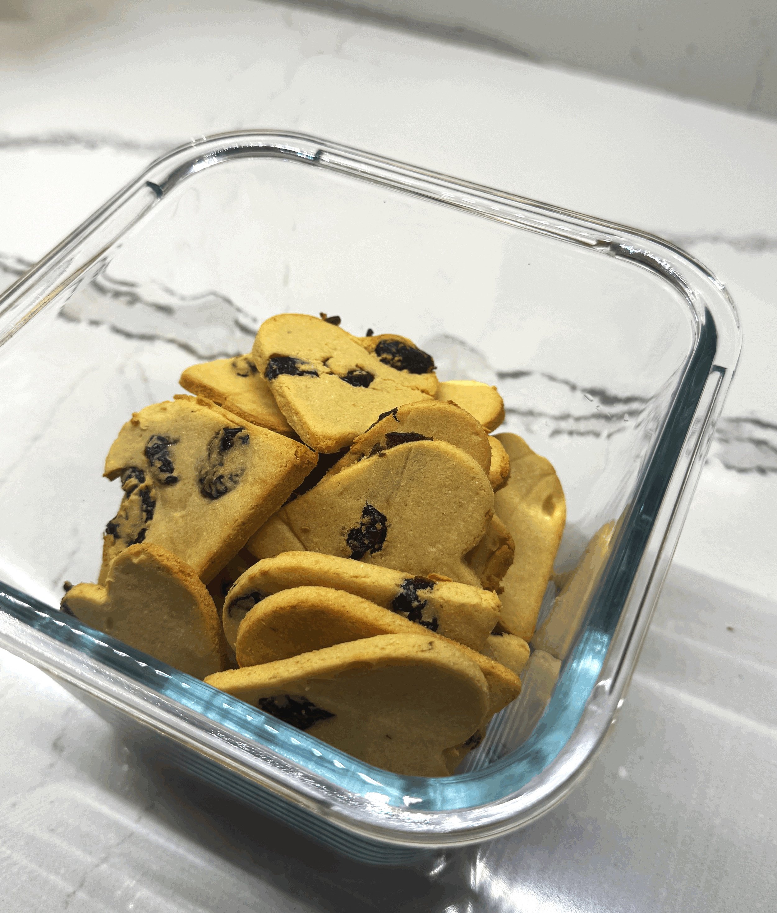 Heart-shaped dog cookies made in Ottawa with organic dried cranberries, almond flour, coconut flour, natural coconut oil, and eggs—grain-free, wholesome treats for dogs.