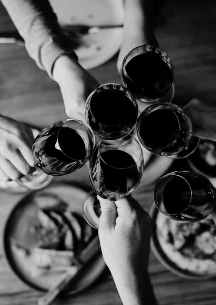 Friends raising glasses of red wine in a toast