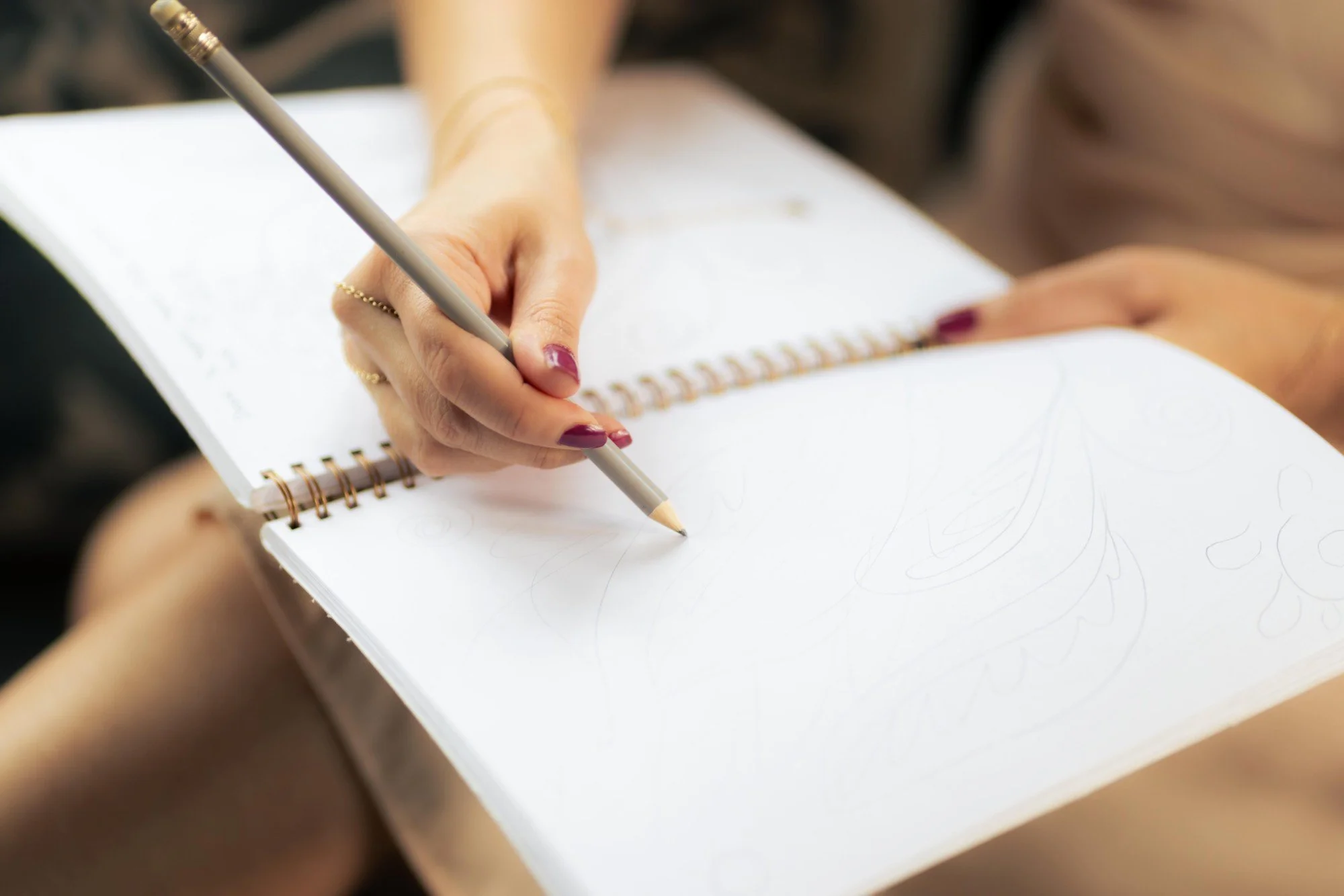 Woman holding a white ceramic bowl with a lit candle, wearing a dress with a floral design.
