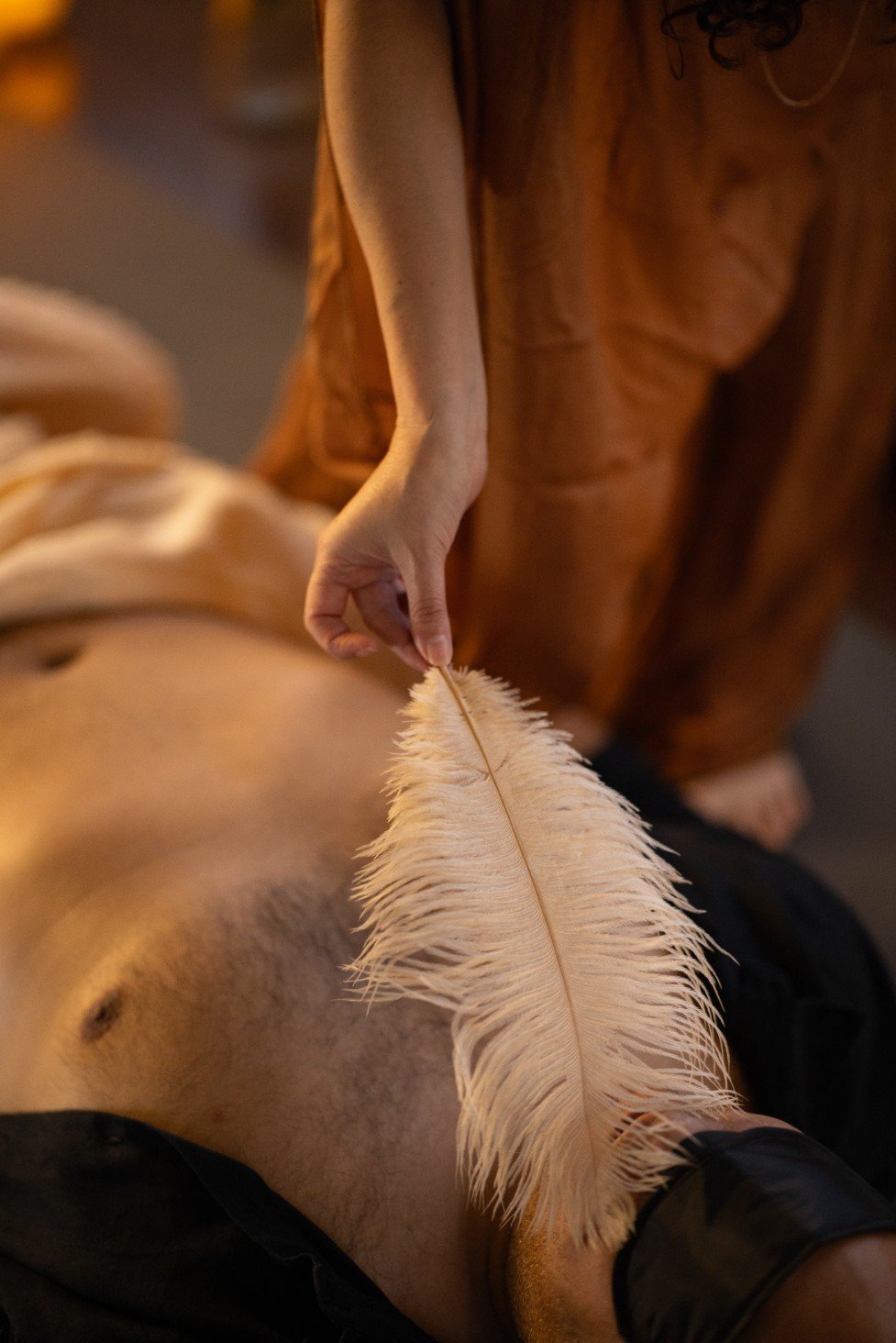 Woman in beige dress wearing layered pearl necklaces and rings