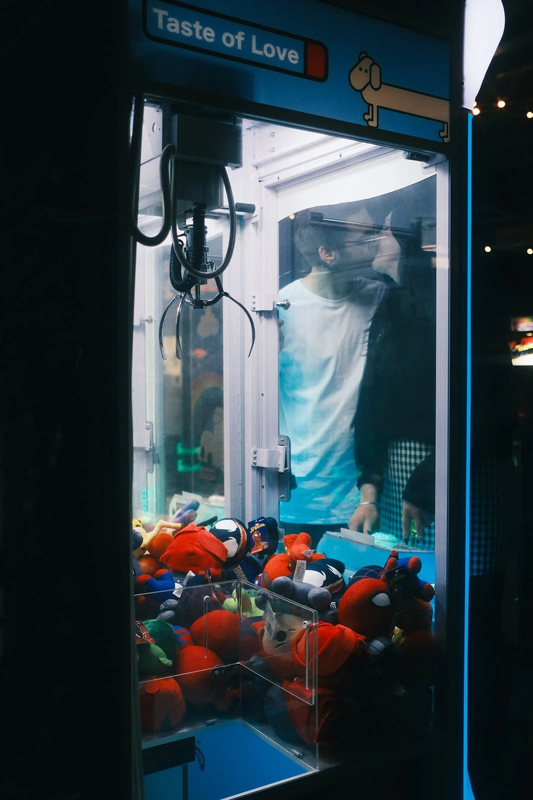 A couple on their engagement shoot in Northcote, Melbourne, at Welcome to Thornbury. They are kissing, while standing at an arcade machine.