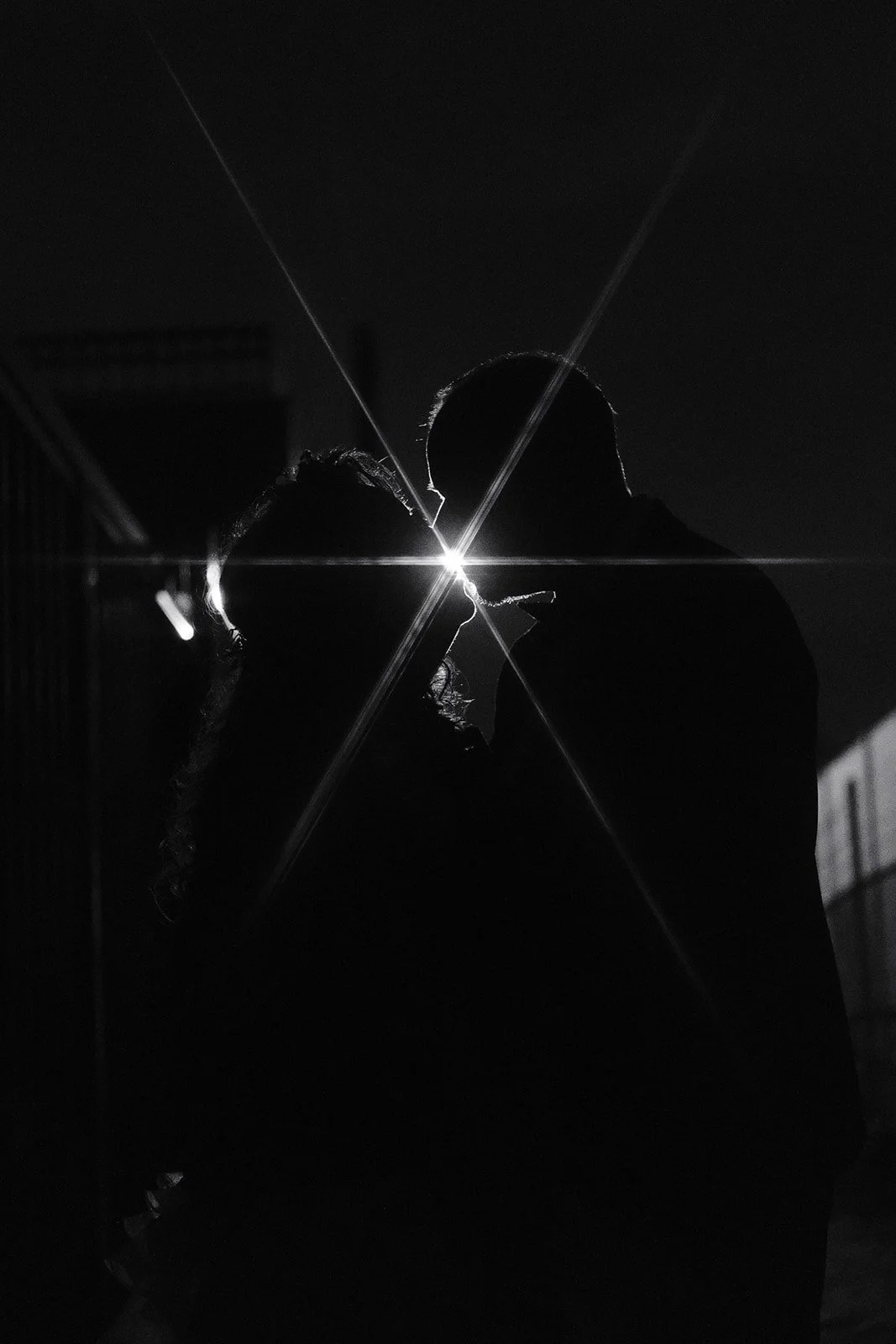 A bride and groom kissing under a streetlight