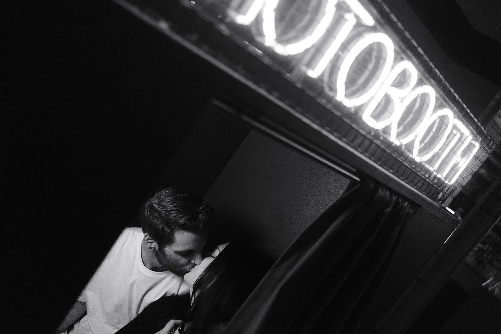 A couple kissing while in a photobooth.