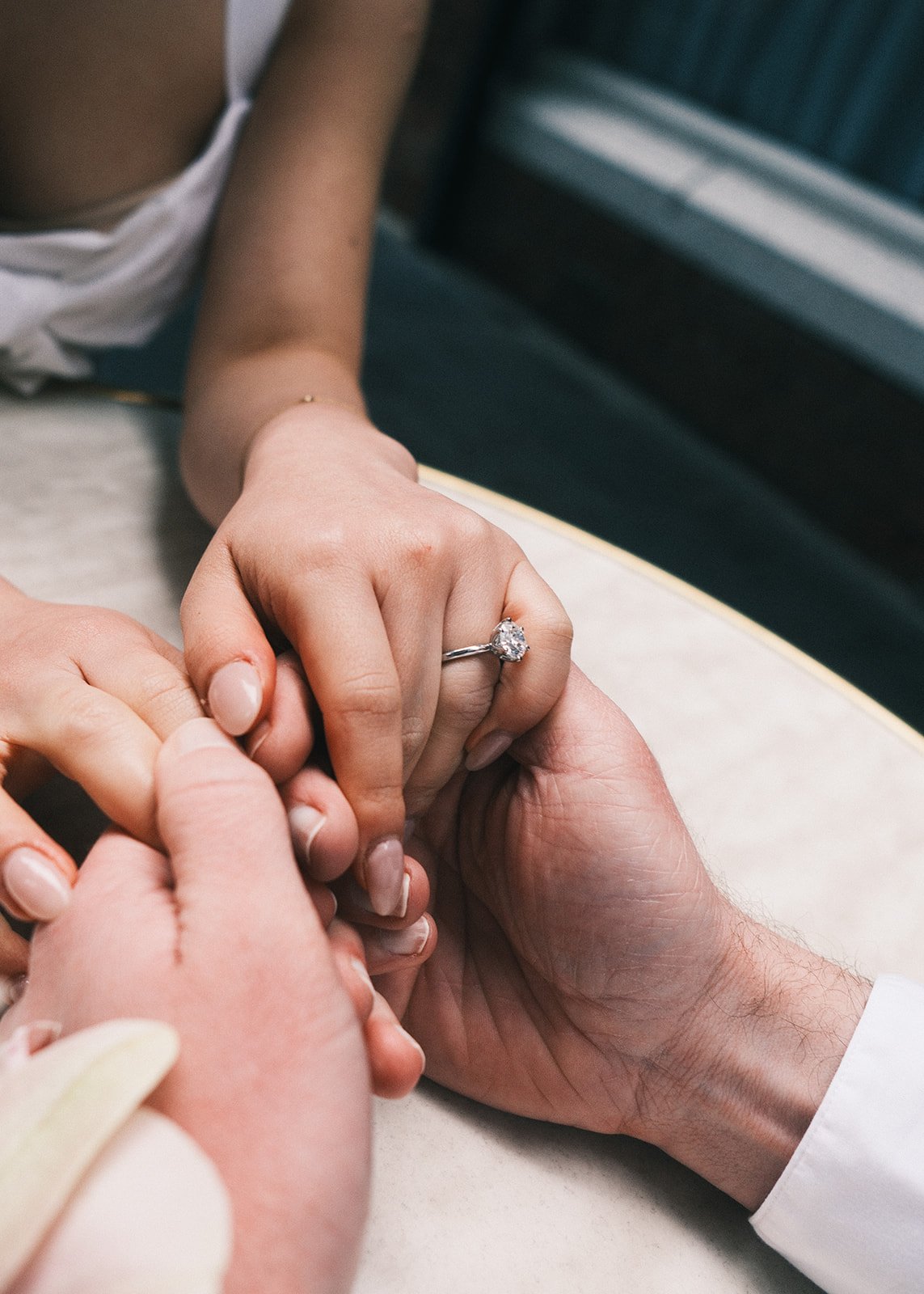 A couple holding hands on their engagement shoot in Melbourne. She is wearing her engagement ring.