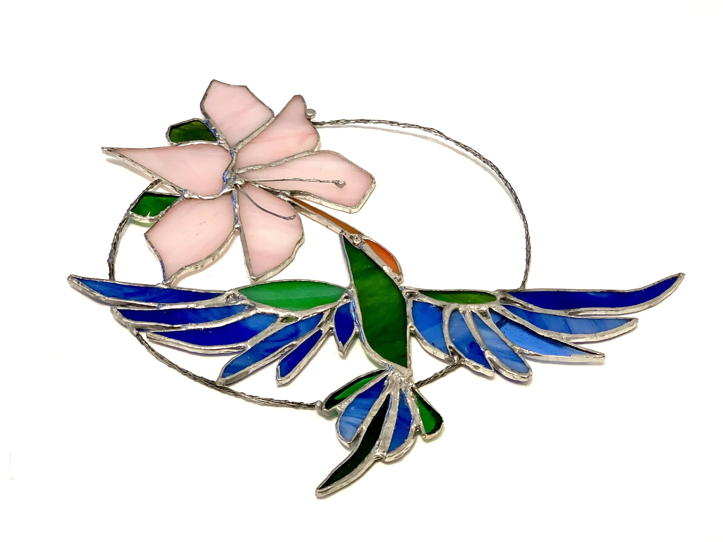 Colorful stained glass sun catcher with a pink lily flower and a blue and green hummingbird.