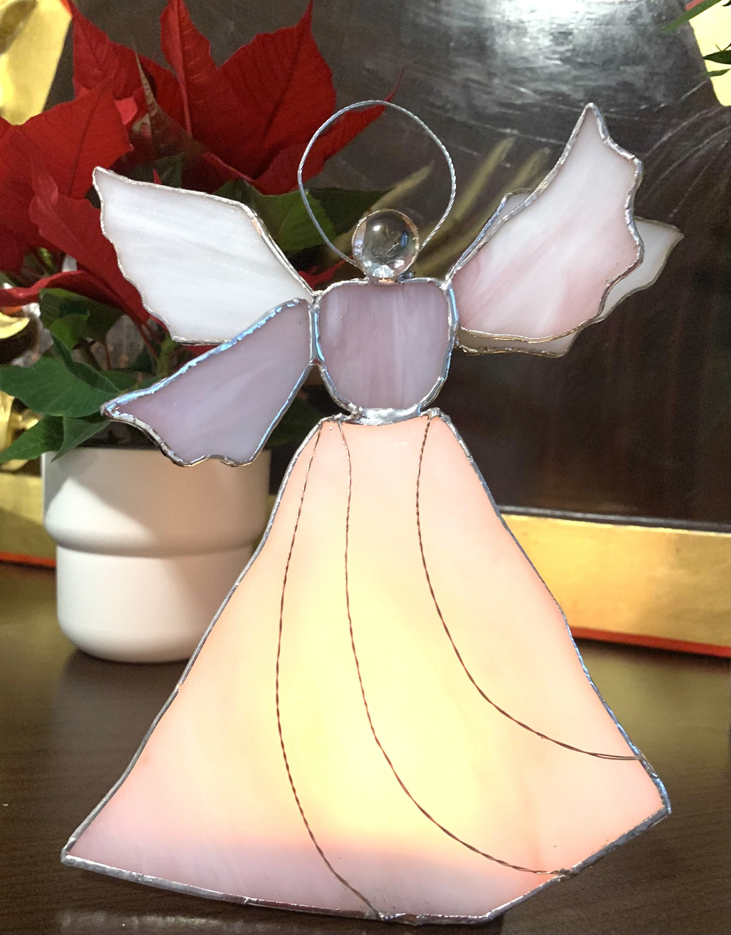 Stained glass angel ornament with pink and purple wings and a flowing peach-colored gown.
