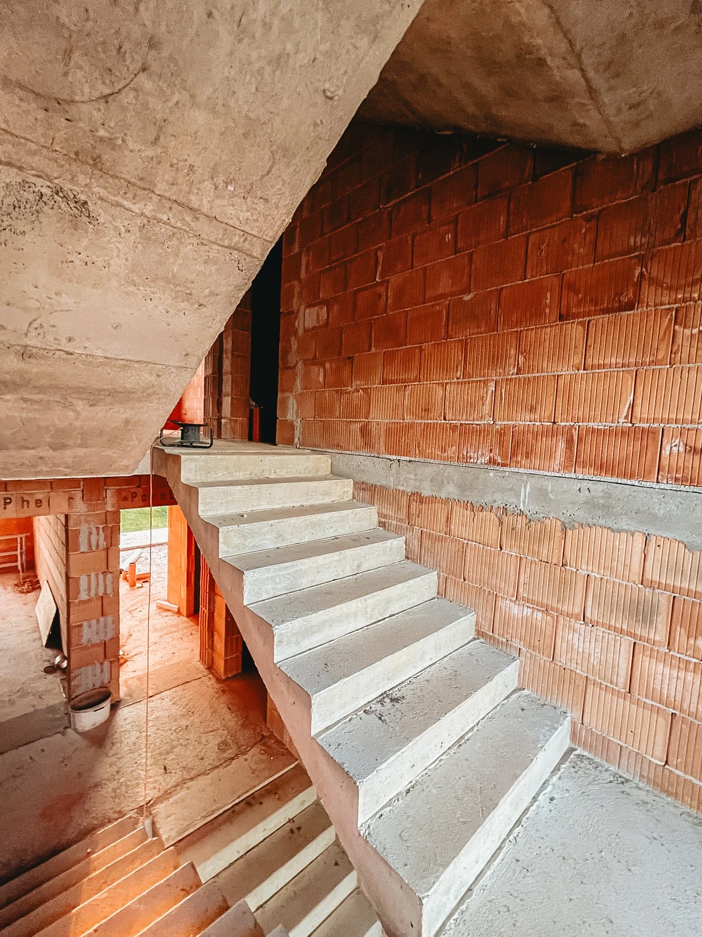 Concrete staircase in an unfinished building with brick walls