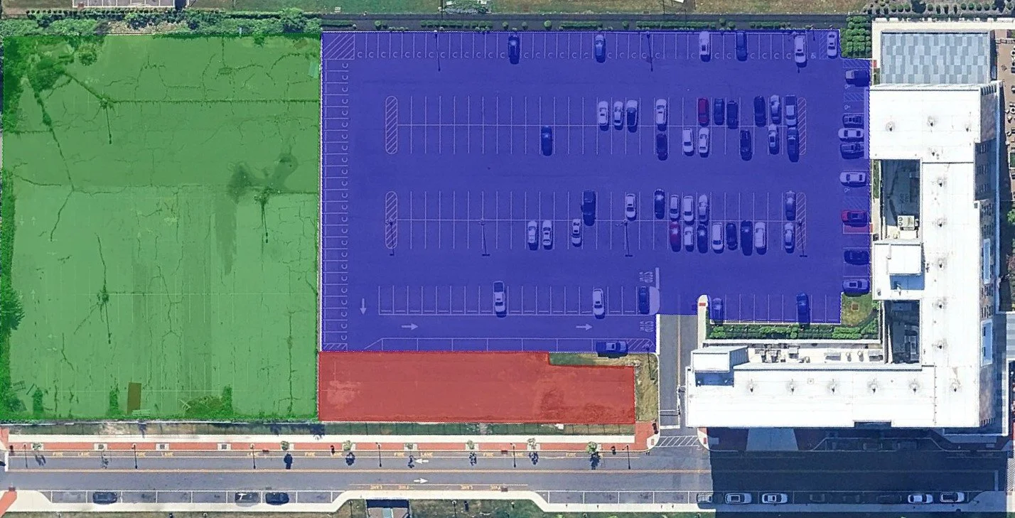 Aerial view highlighting a green, blue, and red parking lot with cars segmented for area analysis and planning
