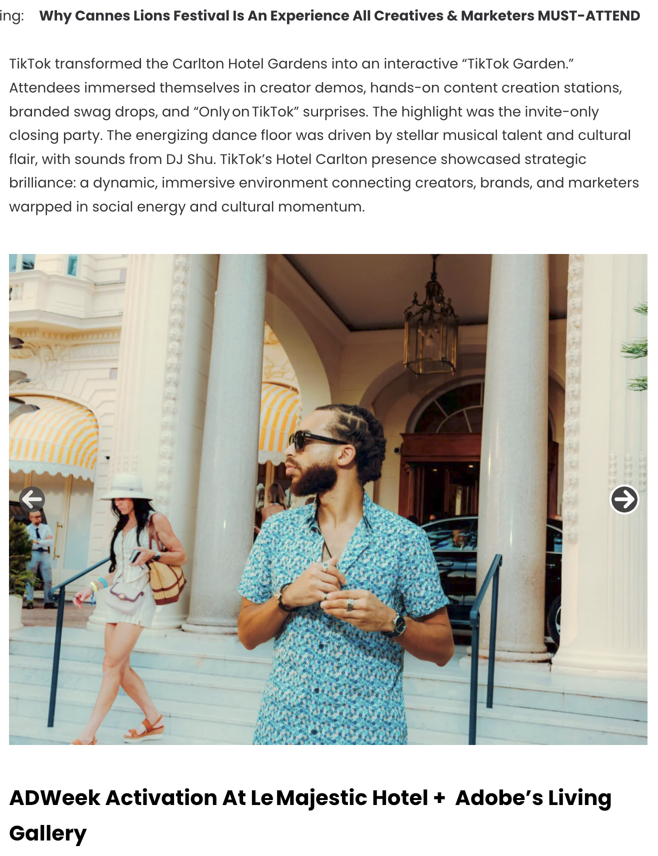 Un homme avec des cheveux tressés portant des lunettes de soleil, une chemise à motifs bleus, et une montre, debout devant un bâtiment élégant avec des colonnes. Une femme portant un chapeau blanc, une robe courte et des sandales marche en arrière-pl