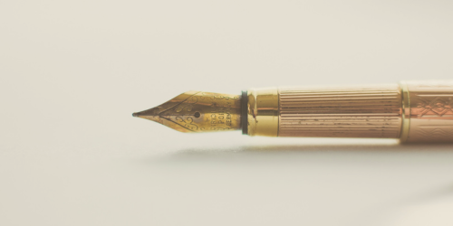 Photo of a golden fountain pen nib pointing to the left.