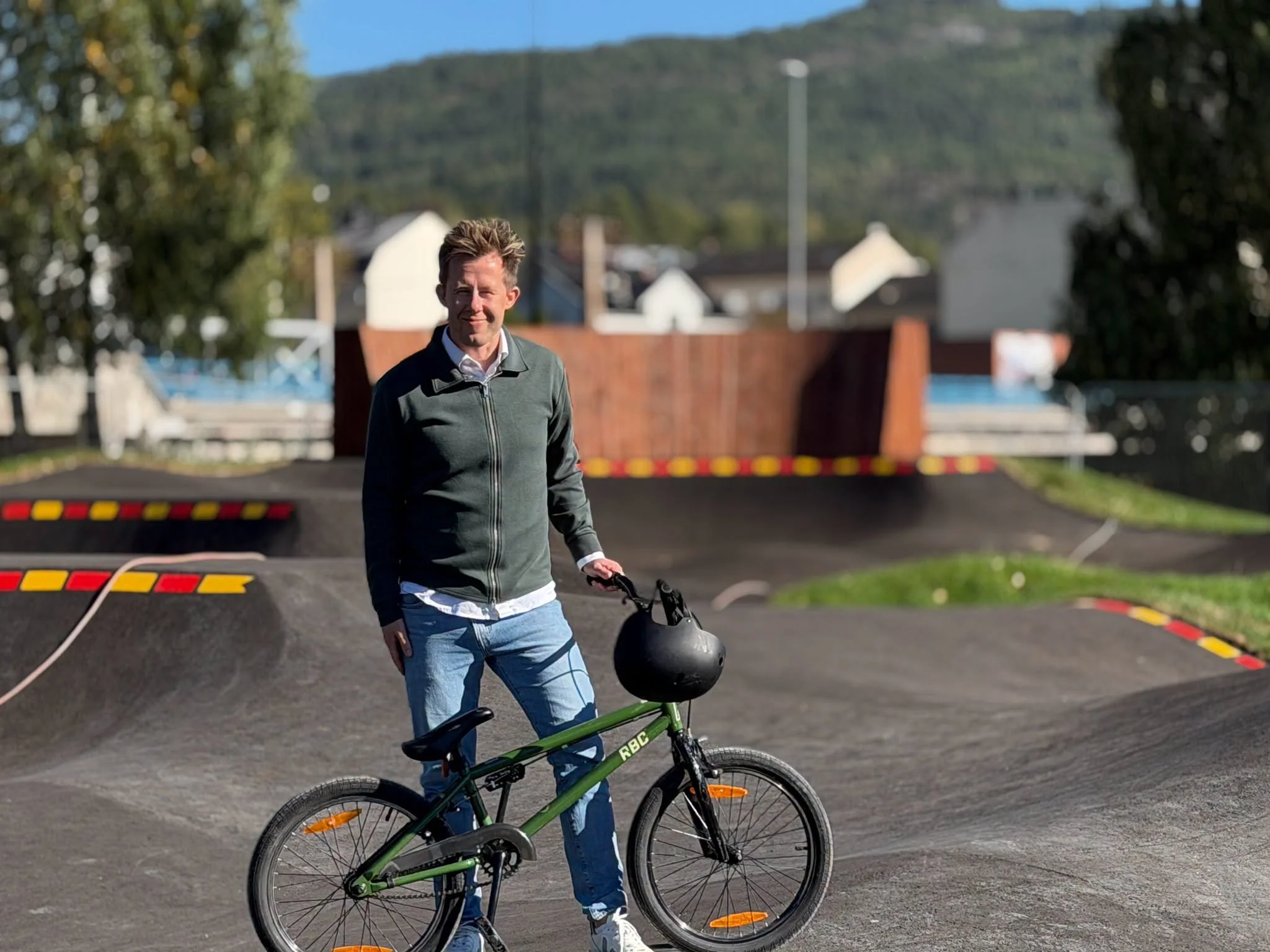 Idrettskonsulent i Notodden kommune, Hans-Olav Johannessen, inviterer store og små til å prøve den nye pumptracken. Foto: Notodden Kommune