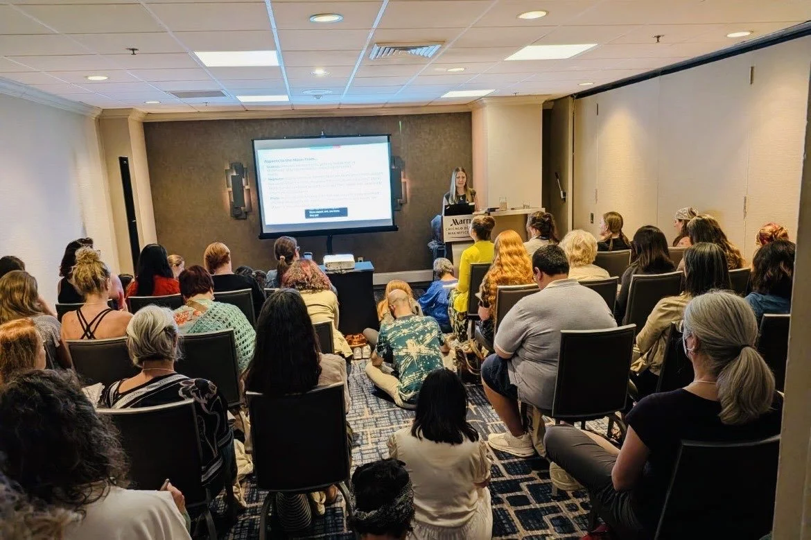 Tara Vogel parenting astrologer speaking to a full conference room of participants