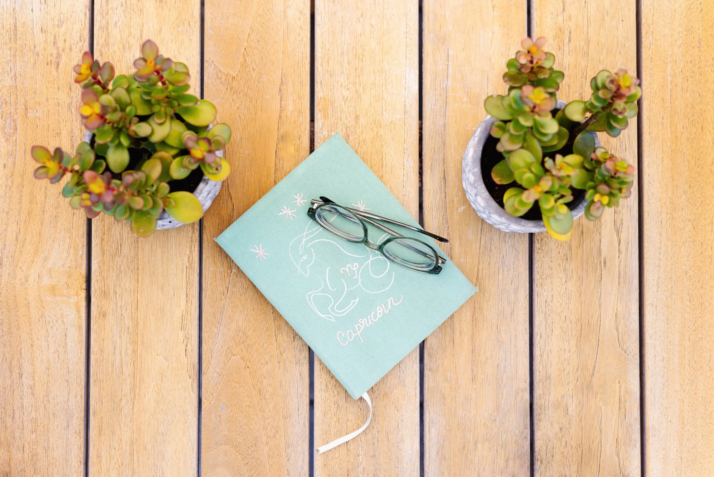 A person in a denim jacket holding a sheet of paper with astronomy charts at a table.